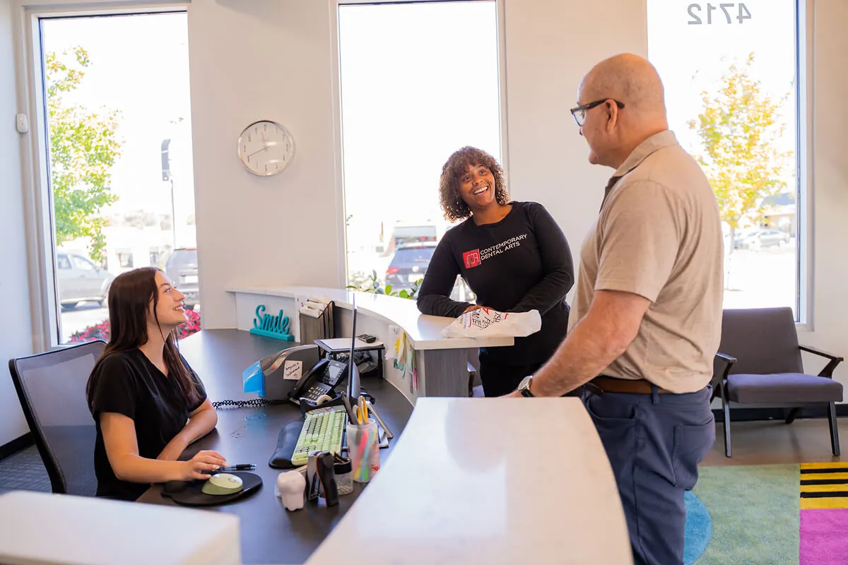 A male patient checking in at the front desk of Tulsa Family Dental in Tulsa OK for an emergency dentist appointment.