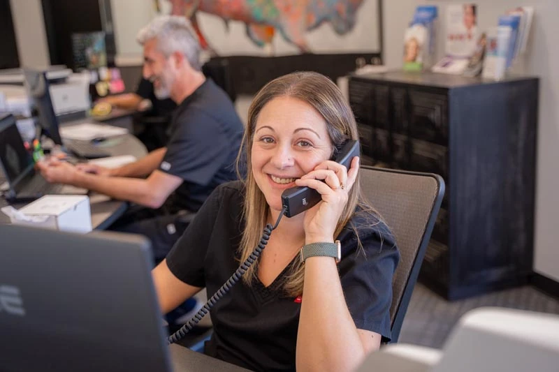 The staff at Contemporary Dental Arts in Tulsa, OK talking with a patient on the phone about clear aligners.