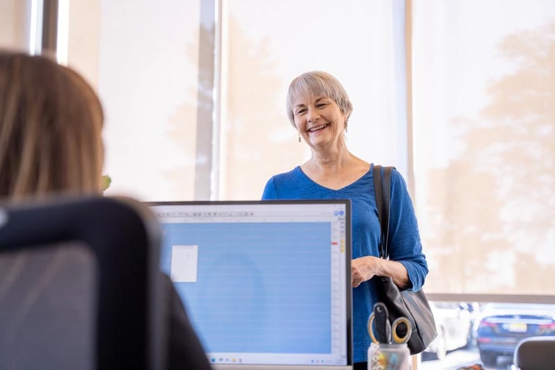 A senior patient speaking with the staff at Contemporary Dental Arts in Tulsa, OK about Dental Implant options.