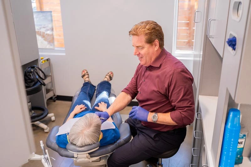 A senior patient speaking with the staff at Contemporary Dental Arts in Tulsa, OK about oral surgery options.