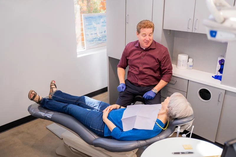 A senior patient speaking with the staff at Contemporary Dental Arts in Tulsa, OK about tooth extractions.